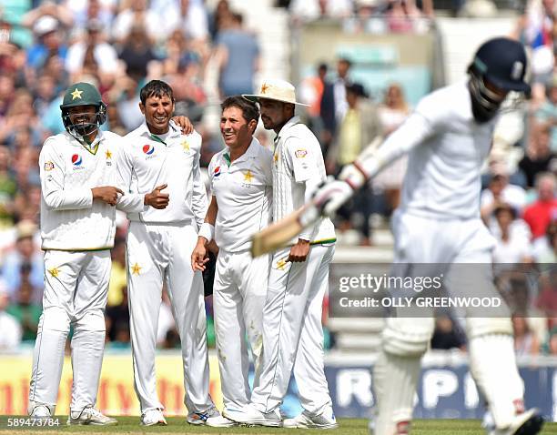 Pakistan's Yasir Shah celebrates with teammates after taking the wicket of England's Moeen Ali during play on the fourth day of the fourth test...