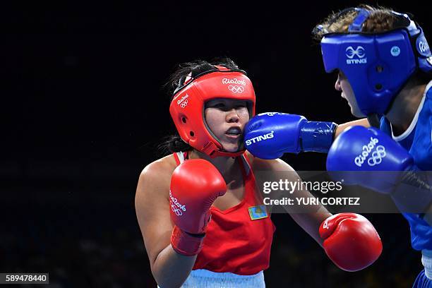 Kazakhstan's Dariga Shakimova is punched by Canada's Ariane Fortin-Brochu during the Women's Middle match at the Rio 2016 Olympic Games at the...