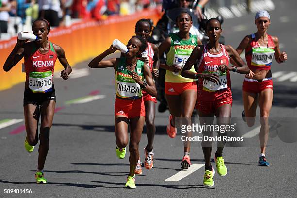 Jemima Jelagat Sumgong of Kenya and Mare Dibaba of Ethiopia compete during the Women's Marathon on Day 9 of the Rio 2016 Olympic Games at the...