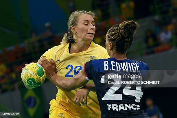 Sweden's centre back Isabelle Gullden vies with France's pivot Beatrice Edwige during the women's preliminaries Group B handball match Sweden vs...