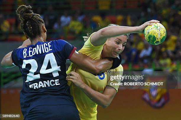 France's pivot Beatrice Edwige vies with Sweden's centre back Isabelle Gullden during the women's preliminaries Group B handball match Sweden vs...