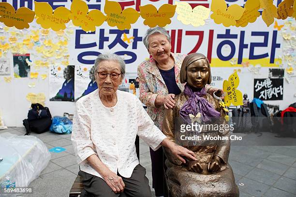Kim Bok-Dong, and Gil Won-Ok sit with The Statu of Girl in front of Japanese Embassy on August 14, 2016 in Seoul, South Korea. The activists held a...