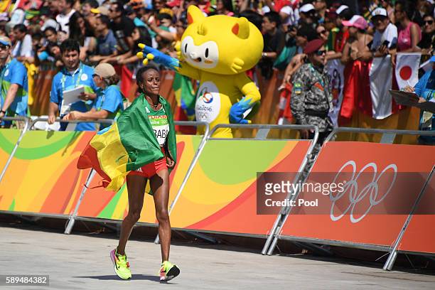 Ethiopia's Mare Dibaba celebrates after finishing third of the Women's Marathon during the athletics event at the Rio 2016 Olympic Games at...