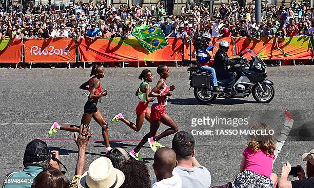 Bahrain's Eunice Jepkirui Kirwa, Ethiopia's Mare Dibaba and Kenya's Jemima Jelagat Sumgong lead the race in the Women's Marathon during the athletics...