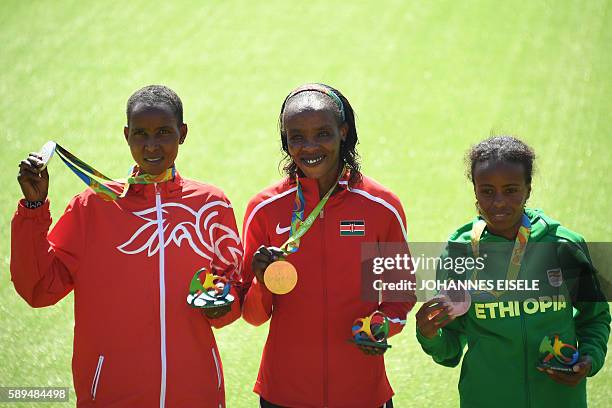 Bahrain's Eunice Jepkirui Kirwa Kenya's Jemima Jelagat Sumgong and Ethiopia's Mare Dibaba pose during the podium ceremony for the Women's Marathon...