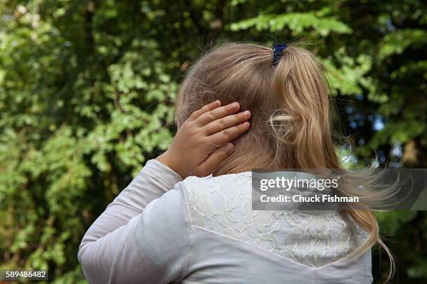 In the Powazki military cemetery, a young girl holds her hands over her ears as she attends a memorial of the 72nd anniversary of the Warsaw...