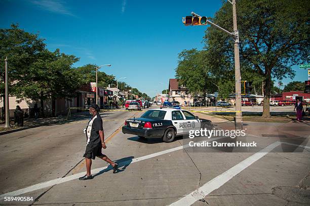 People survey damage to a few local business after rioters clashed with the Milwaukee Police Department protesting an officer involved killing August...