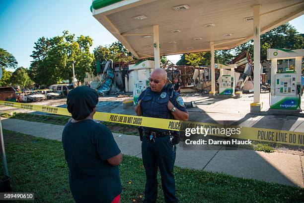 Police officer stands guard in front of the BP gas station after rioters clashed with the Milwaukee Police Department protesting an officer involved...