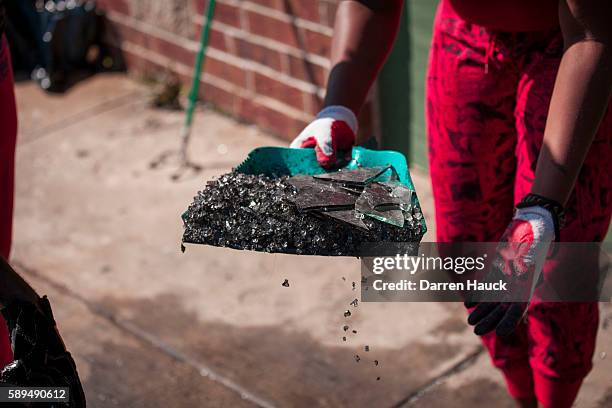 Community members and volunteers help clean up the damage to a few local business after rioters clashed with the Milwaukee Police Department...