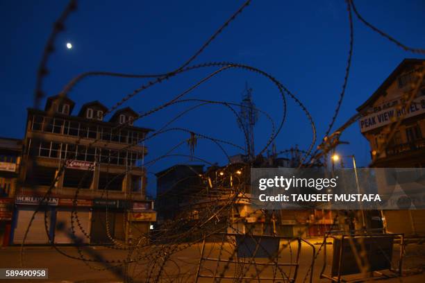 This photo taken on August 14, 2016 shows a barbed-wire fence during a curfew in Lal Chowk in Srinagar on August 14 part of tightened security in...