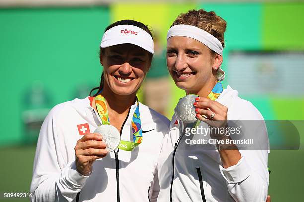 Silver medalists Timea Bacsinszky and Martina Hingis of Switzerland pose on the podium during the ceremony for the women's doubles on Day 9 of the...