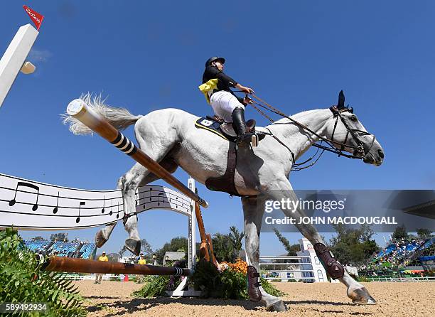 Italy's Emanuele Gaudiano on Caspar 232 crashes through an obstacle during the Equestrian's Show Jumping first qualifier event of the 2016 Rio...