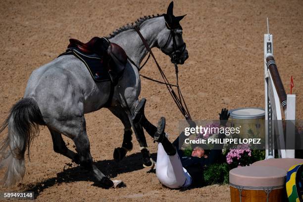 Ukraine's Cassio Rivetti falls as he competes during the equestrian's jumping individual and team qualifier event of the Rio 2016 Olympic Games at...
