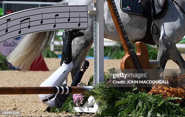 Ukraine's Cassio Rivetti on Fine Fleur du Marais falls off his horse during the Equestrian's Show Jumping first qualifier event of the 2016 Rio...