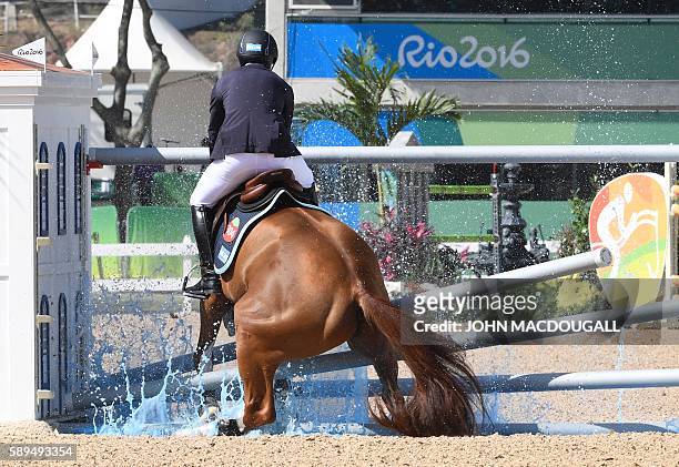 Brazil's Eduardo Menezes on Quintol hits an obstacle during the Equestrian's Show Jumping first qualifier event of the 2016 Rio Olympic Games at the...