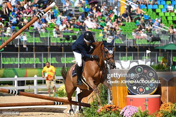 Chinese Taipei's Isheau Wong on Zadarijke V crashes through an obstacle during the Equestrian's Show Jumping first qualifier event of the 2016 Rio...