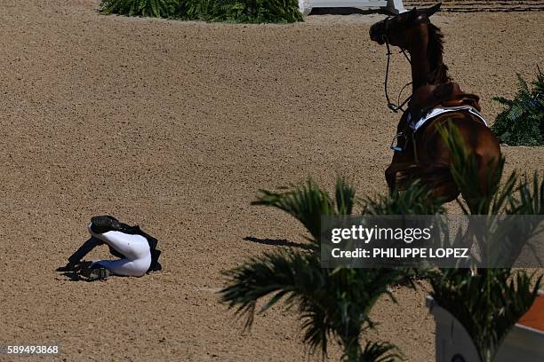 France's Penelope Leprevost falls during the equestrian's jumping individual and team qualifier event of the Rio 2016 Olympic Games at the Olympic...