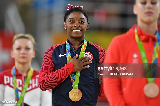 Russia's Maria Paseka, US gymnast Simone Biles and Switzerland's Giulia Steingruber celebrate on the podium for the women's vault event final of the...