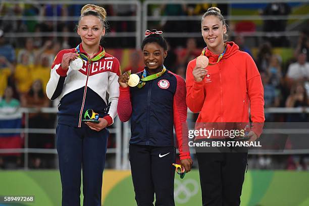 Russia's Maria Paseka, US gymnast Simone Biles and Switzerland's Giulia Steingruber celebrate on the podium for the women's vault event final of the...