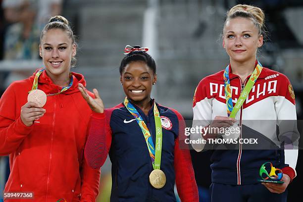 Russia's Maria Paseka, US gymnast Simone Biles and Switzerland's Giulia Steingruber celebrate on the podium for the women's vault event final of the...