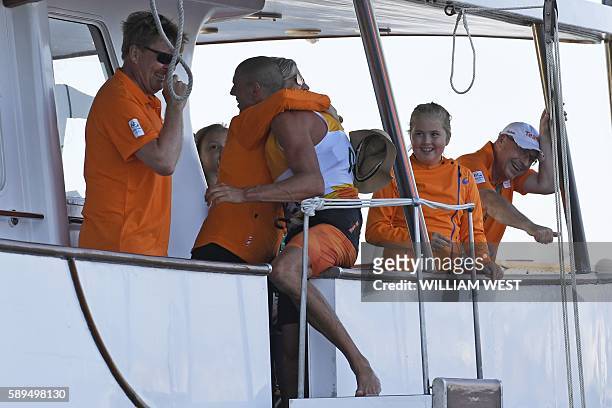 Netherlands' Dorian Van Rijsselberghe is congratulated by Netherland's King Willem-Alexander and Queen Maxima after he won the RS:X Men sailing final...