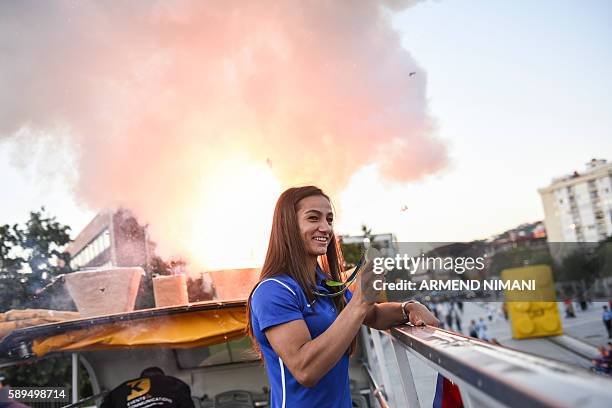 Kosovo's judoka Majlinda Kelmendi shows her gold medal to the supporters during a welcoming ceremony in Pristina on August 14, 2016. Majlinda...