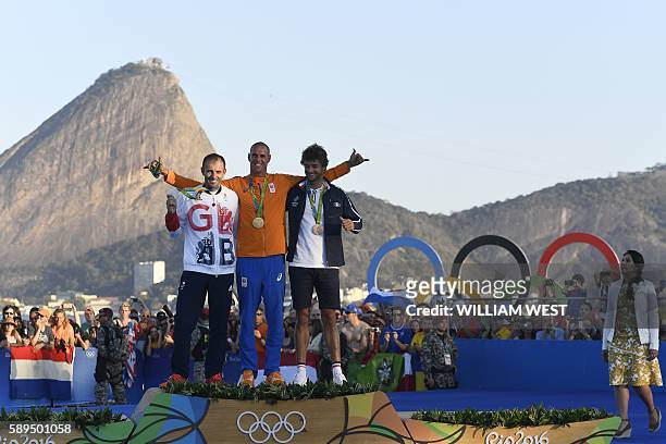 Netherlands' gold medallist Dorian Van Rijsselberghe , Britain's silver medallist Nick Dempsey and France's bronze medallist Pierre Le Coq pose on...