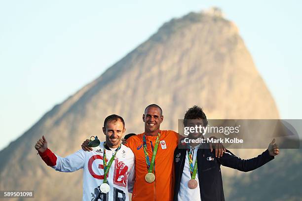Silver medalist Nick Dempsey of Great Britain, gold medalist Dorian van Rijsselberghe of the Netherlands and bronze medalist Pierre le Coq of France...