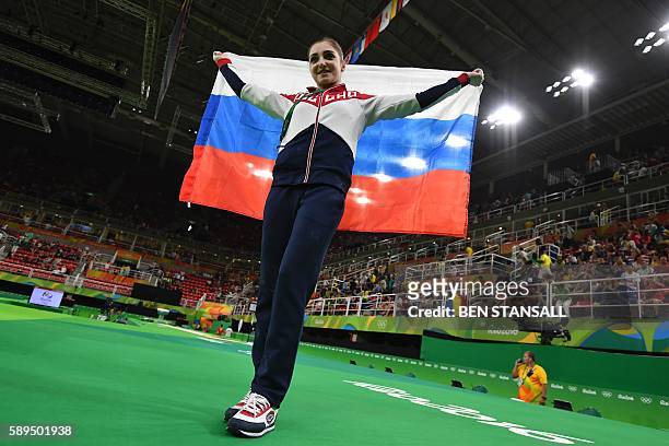 Russia's Aliya Mustafina celebrates after winning the women's uneven bars event final of the Artistic Gymnastics at the Olympic Arena during the Rio...
