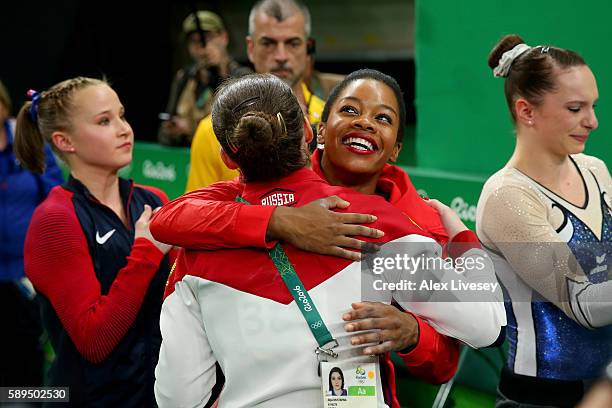 Aliya Mustafina of Russia is congratulated byGabrielle Douglas of the United States on winning the gold medal after the Women's Uneven Bars Final on...