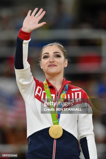 Russia's Aliya Mustafina celebrates on the podium of the women's uneven bars event final of the Artistic Gymnastics at the Olympic Arena during the...