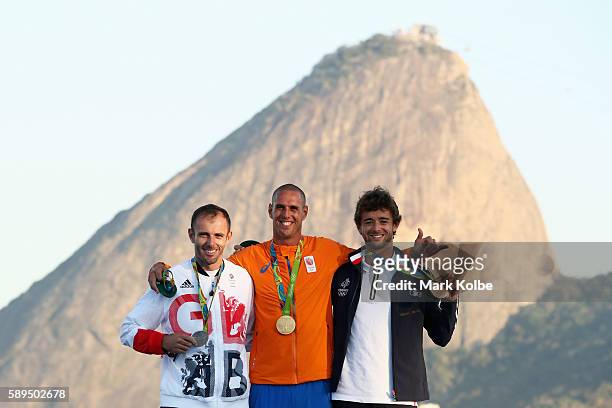 Silver medalist Nick Dempsey of Great Britain, gold medalist Dorian van Rijsselberghe of the Netherlands and bronze medalist Pierre le Coq of France...