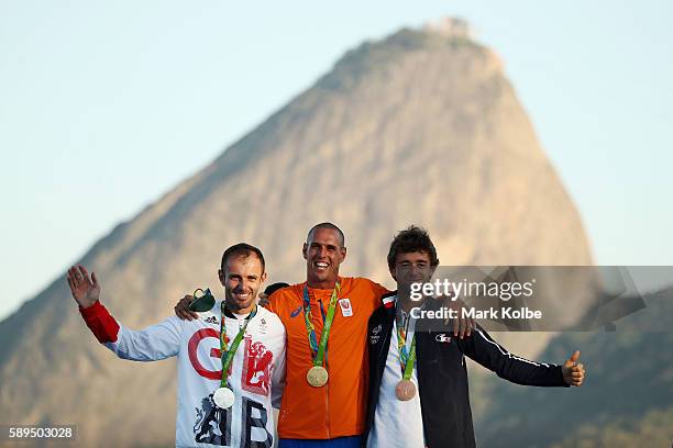 Silver medalist Nick Dempsey of Great Britain, gold medalist Dorian van Rijsselberghe of the Netherlands and bronze medalist Pierre le Coq of France...