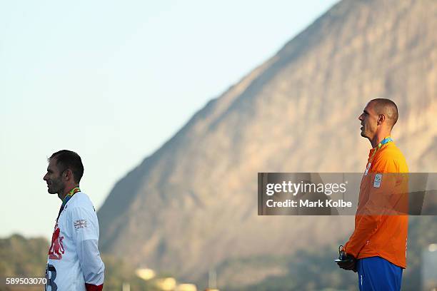 Silver medalist Nick Dempsey of Great Britain and gold medalist Dorian van Rijsselberghe of the Netherlands celebrate on the podium following the...