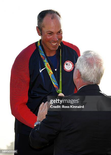 Wada president Craig Reedie presets the bronze medal to Matt Kuchar of the United States after the final round of men's golf on Day 9 of the Rio 2016...