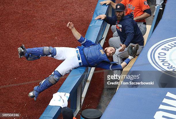 Russell Martin of the Toronto Blue Jays catches a foul pop up in the seventh inning during MLB game action and avoids falling into the Houston Astros...