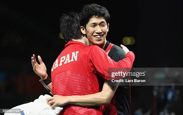 Maharu Yoshimura of Japan celebrates with Jun Mizutani after winning the Table Tennis Men's Quarterfinal Match between Japan and Hong Kong on August...