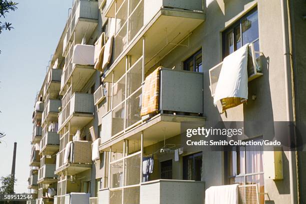 On the balconies of an apartment complex, residents have hung blankets to dry, Gloucestershire, United Kingdom, 1952. .