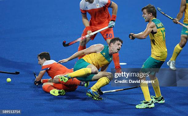 Simon Orchard of Australia is brought down during the Men's hockey quarter final match between the Netherlands and Australia on Day 9 of the Rio 2016...
