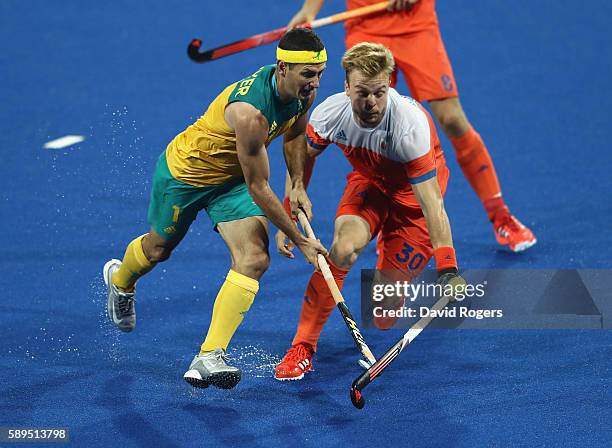 Jamie Dwyer of Australia is challenged by Mink van der Weerden during the Men's hockey quarter final match between the Netherlands and Australia on...