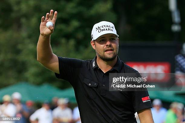Ryan Moore acknowledges the crowd after his winning putt on the 18th green during the final round of the John Deere Classic at TPC Deere Run on...