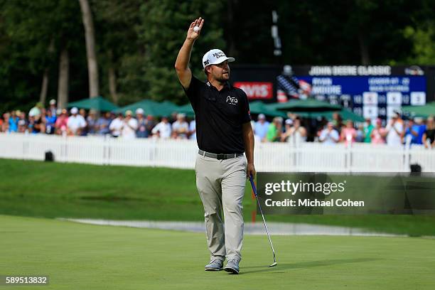 Ryan Moore acknowledges the crowd after his winning putt on the 18th green during the final round of the John Deere Classic at TPC Deere Run on...