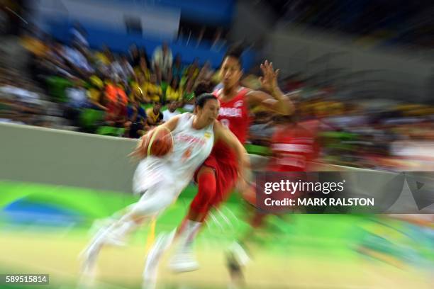 Spain's point guard Silvia Dominguez works around Canada's power forward Miranda Ayim during a Women's round Group B basketball match between Spain...