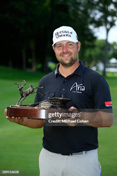 Ryan Moore holds the trophy after winning the John Deere Classic during the final round of the John Deere Classic at TPC Deere Run on August 14, 2016...