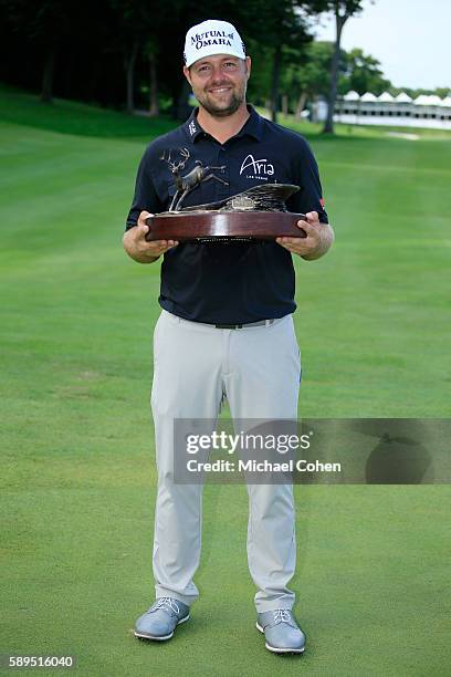 Ryan Moore holds the trophy after winning the John Deere Classic during the final round of the John Deere Classic at TPC Deere Run on August 14, 2016...