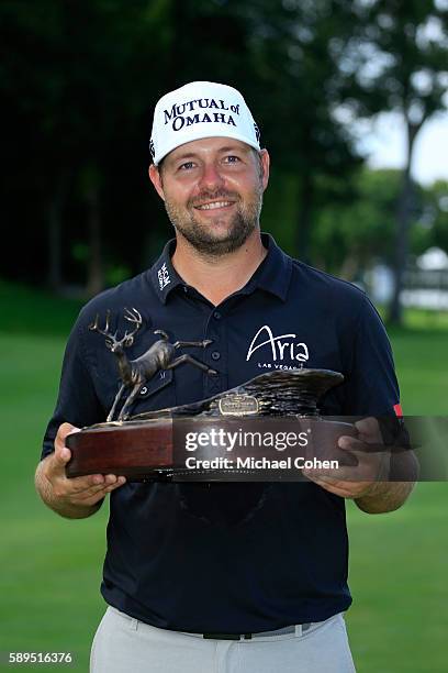Ryan Moore holds the trophy after winning the John Deere Classic during the final round of the John Deere Classic at TPC Deere Run on August 14, 2016...