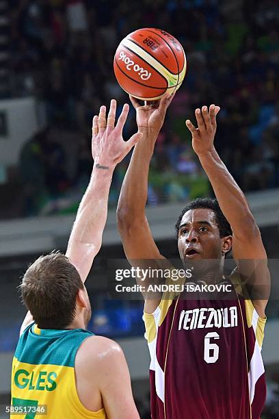 Venezuela's shooting guard John Cox takes a shot over Australia's small forward Joe Ingles during a Men's round Group A basketball match between...