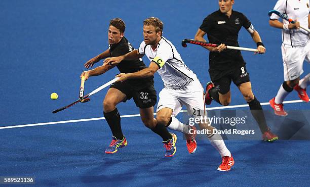 Nick Wilson of New Zealand is challenged by Moritz Furste during the Men's hockey quarter final match between the Germany and New Zealand on Day 9 of...