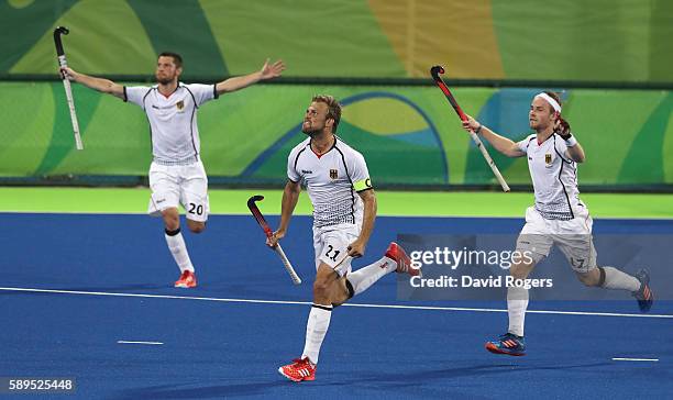 Moritz Furste, of Germany who scored a late equalising goal celebrates with team mates Christopher Ruhr and Martin Zwicker during the Men's hockey...