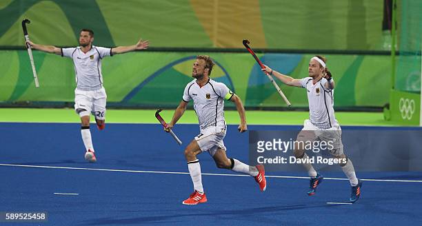 Moritz Furste, of Germany who scored a late equalising goal celebrates with team mates Christopher Ruhr and Martin Zwicker during the Men's hockey...